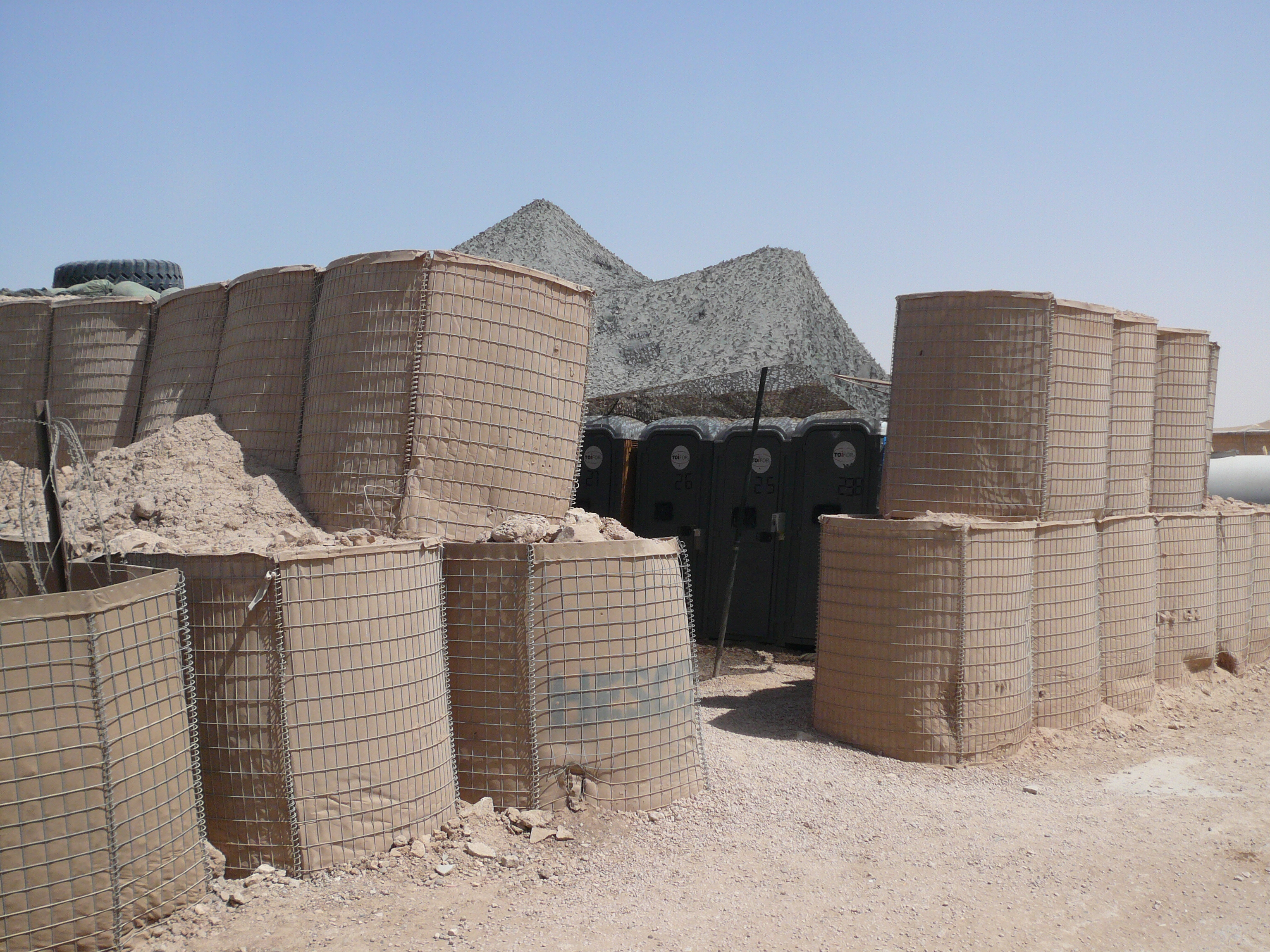 Filled earth-filled barriers stacked at a forward operating base