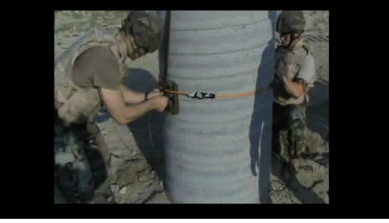 Soldiers placing a shaped breach charge against a cast concrete column